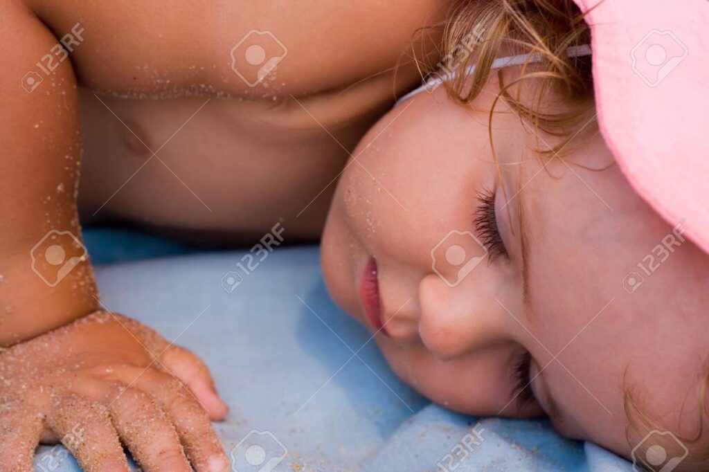 La dulce siesta de una niña en la playa